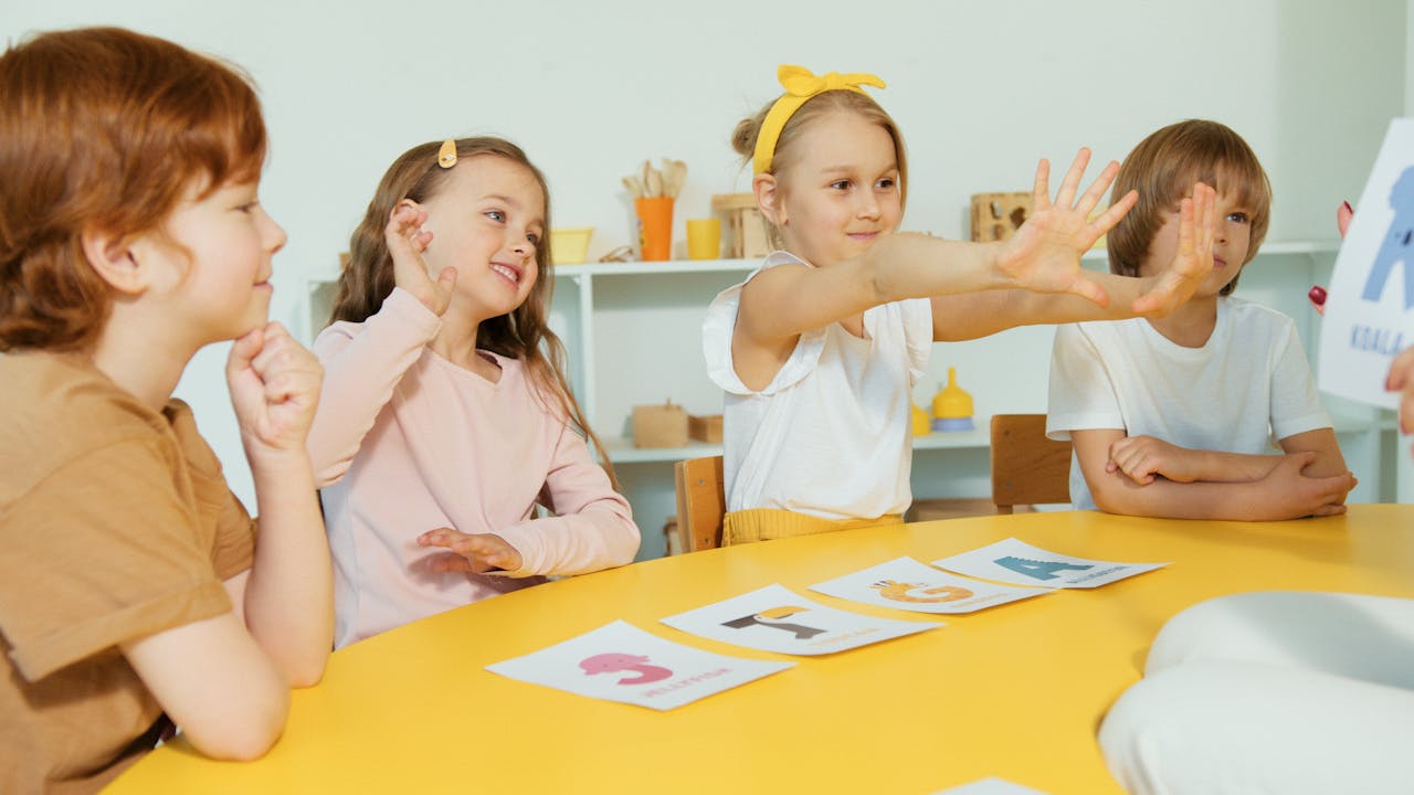 Happy kids engaging with alphabet cards around a table in a classroom
